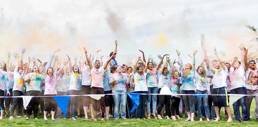  Participants at Holi, hosted by EIU Study Abroad, throw colored powder up in the air on the Library Quad on Friday.