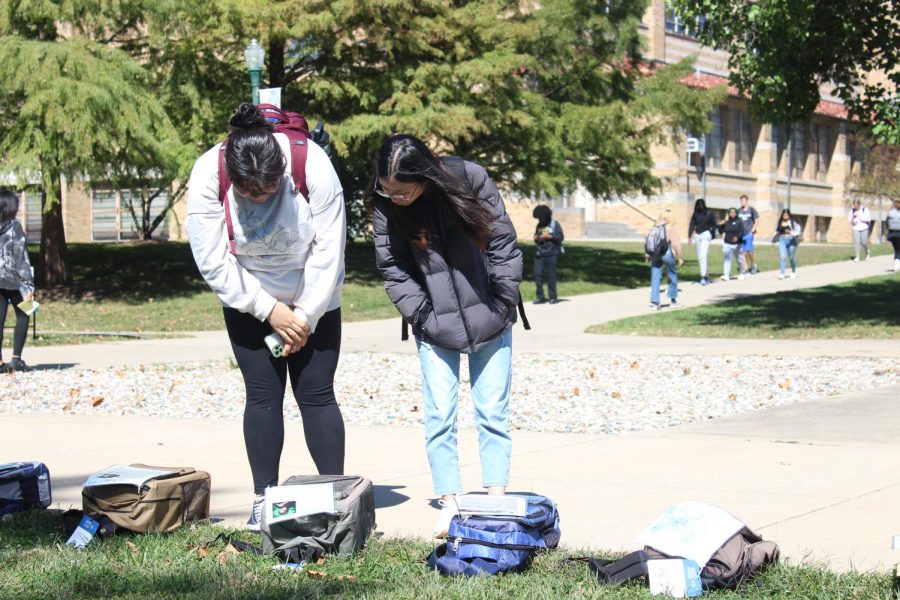 Yujin Eun, a second year grad student clinical psychology, and Alejandra Huerta Hernandez, a second year grad student of clinical psychology, view the many backpacks spread across the Library Quad that showcase personal stories of people who have lost their lives to suicide and those who have survived.