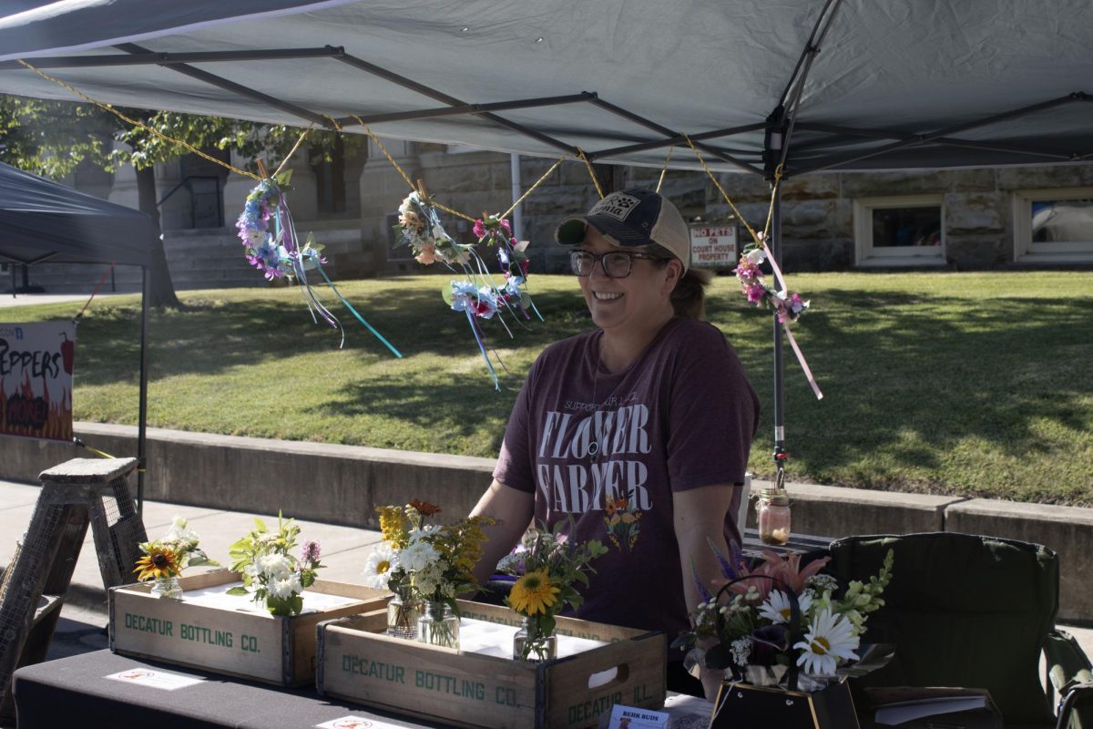 Christina Behrend greeting customers at her stall on June 15. Behrend earned her masters at Eastern in 1996. This is her second year at the Farmers Market.