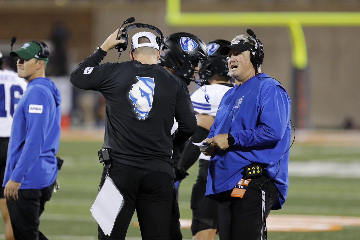 EIU football head football coach Chris Wilkerson confers with another member of the coaching staff during the team's season opener against the University of Illinois at Urbana-Champaign Fighting Illini at Memorial Stadium Thursday night.