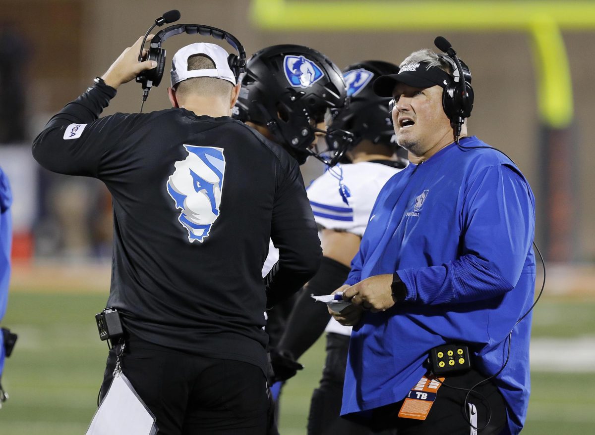 EIU football head football coach Chris Wilkerson confers with another member of the coaching staff during the team's season opener against the University of Illinois at Urbana-Champaign Fighting Illini at Memorial Stadium Thursday night.