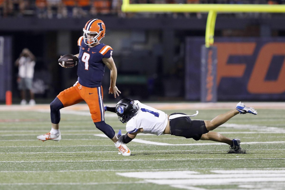 Illinois junior quarterback Luke Altmyer scrambles evading past Eastern Illinois University defense during the team's season opener against the Fighting Illini at Memorial Stadium Thursday night. The Panthers were shut out 45-0 to the Fighting Illini. 