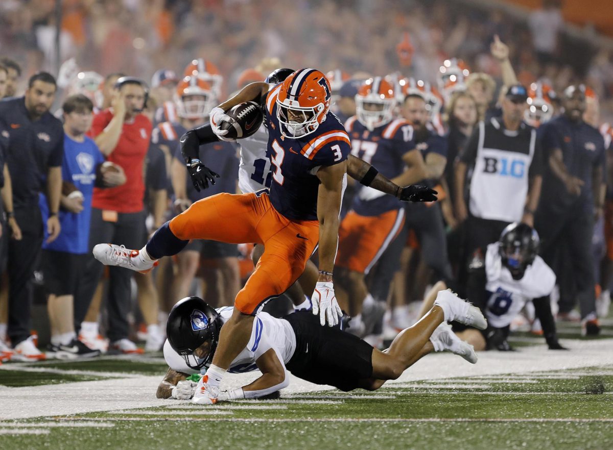 Fighting Illini Kaden Feagin hurdles past the EIU senior defensive back Zay Gentry during the team's season opener against the Fighting Illini at Memorial Stadium Thursday night.