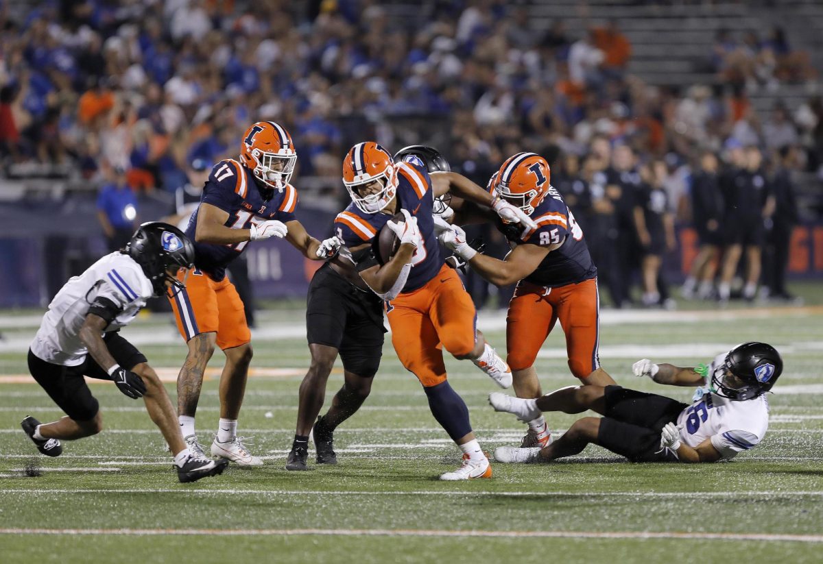 Illinois sophomore running back Kaden Feagin slips past the EIU defensive line during the team's season opener against the Fighting Illini at Memorial Stadium Thursday night.