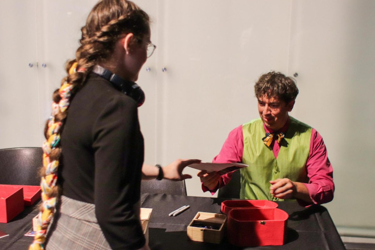 SUBMITTED PHOTO | THE DOUDNA FINE ARTS CENTER
Greg Jukes autographs a playbill for a student after "Fruit Flies Like a Banana" performance at The Theatre in the Doudna Fine Arts Center Saturday.