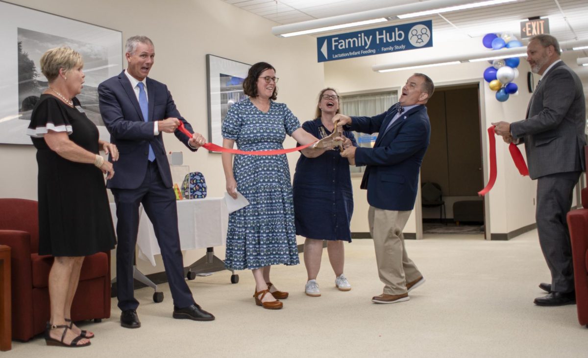 President Jay Gatrell (middle right), joined with Amy Odwarka (middle), and Michele McDaniel (middle left) cut the ribbon to open the new family hub in on the fourth floor of the Booth Library on the Eastern Illinois University campus Wednesday.