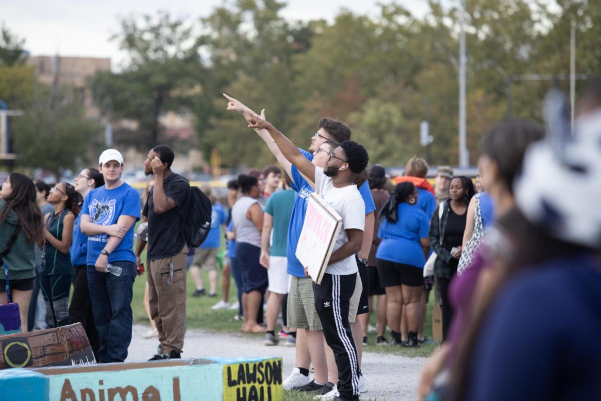 Students participate in Neighborhood Week, with cardboard boat racing, each group representing a different hall. Taylor Hall's boat won first in the design competition.