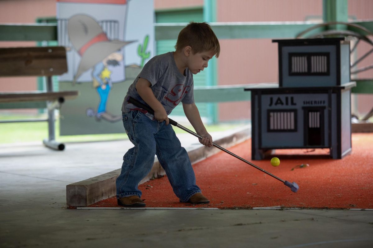 Braden Closson plays mini golf at Camp New Hope during Camp New Hopes 50th Anniversary celebration.