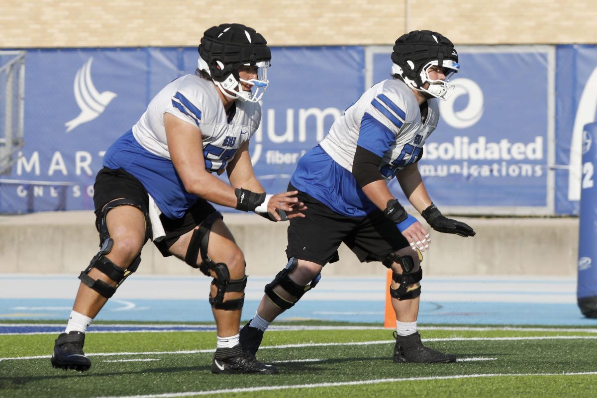 Sophomore offensive lineman Nic DiSanto (right) runs through drills during football practice at O'Brien Field Wednesday afternoon.