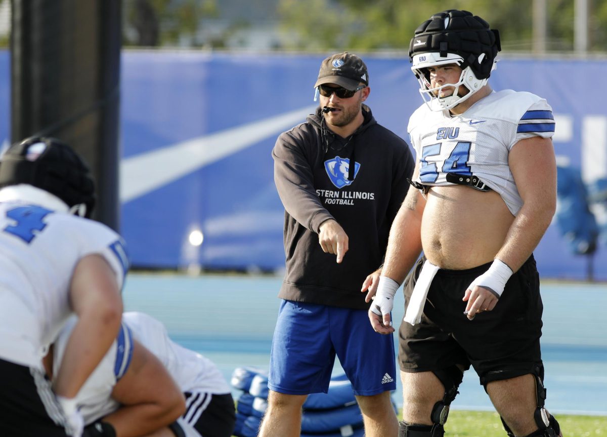 Offensive line coach John Cannova instructs sophomore offensive lineman Nic DiSanto (54) on proper form during football practice at O'Brien Field Wednesday afternoon.