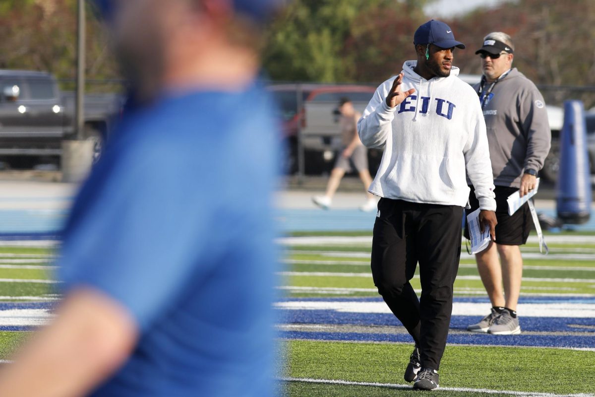 Wide receivers coach Tino Smith instructs players to reset a play during football practice at O'Brien Field Wednesday morning. 