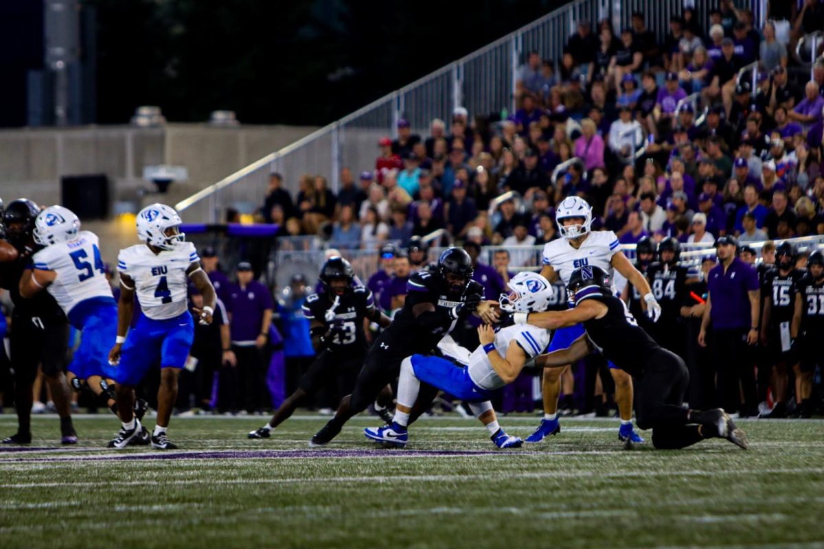 Graduate quarterback Pierce Holley gets tackled by two Northwestern defenders. Eastern lost to Northwestern Saturday evening in Evanston with a final score of 31-7 at Northwestern Medicine Field at Martin Stadium.