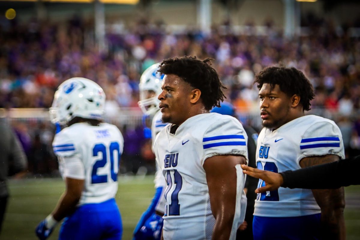 Senior linebacker Elijawah Tolbert (center) and redshirt freshman defensive lineman Trevon Piggee-Blake (right) look on out to the Northwestern Medicine Field at Martin Stadium from the sideline. Eastern lost to Northwestern Saturday evening in Evanston with a final score of 31-7.