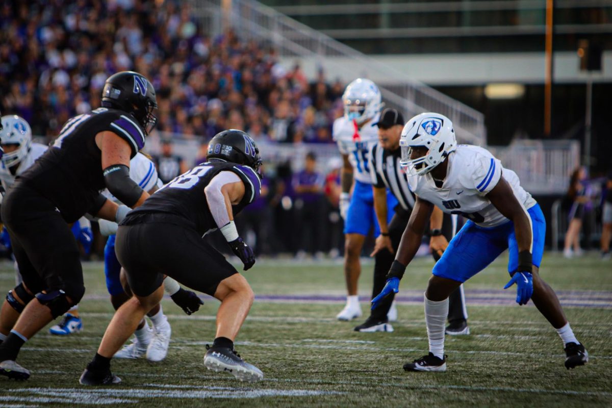 Senior defensive lineman Joel Barrows lines up against a Northwestern defender before a snap. Eastern lost to Northwestern Saturday evening in Evanston with a final score of 31-7 at Northwestern Medicine Field at Martin Stadium.