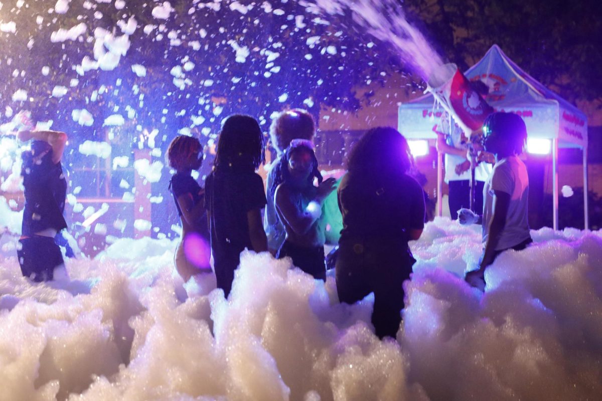 Students enjoy the mess of foam as they play at the Glow Foam Party.