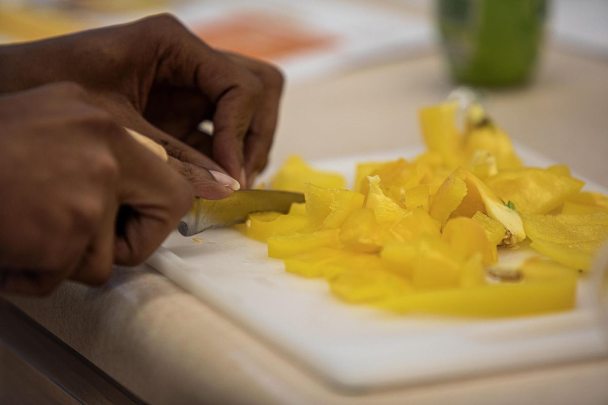 David Motton, a senior health science major, cuts yellow peppers to make meatless tacos during the healthy cooking class in Klehm Hall on the Eastern Illinois University campus, Sept. 16, 2024. Motton says this is an opportunity for students because "they can expand their horizon, diversity and I like tacos and to learn about culture."