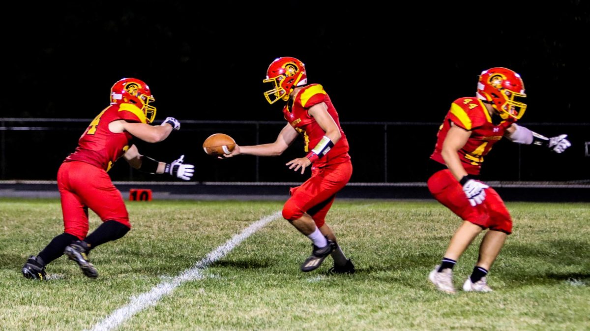 Charleston senior quarterback hands the ball off to senior running back Ben Coffey during Charleston’s 45-34 win against Jersey on 