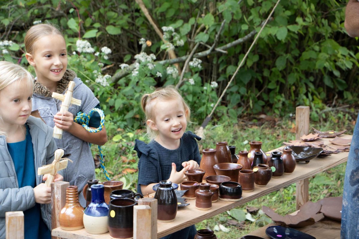 Children Savannah (left), Melody and Ava Herschberger, with their mom Regina Herschberger (not pictured), admire the pottery work of father and son Jacob and Isaac Venatta at the Lincoln Log Cabin State Historic Site.