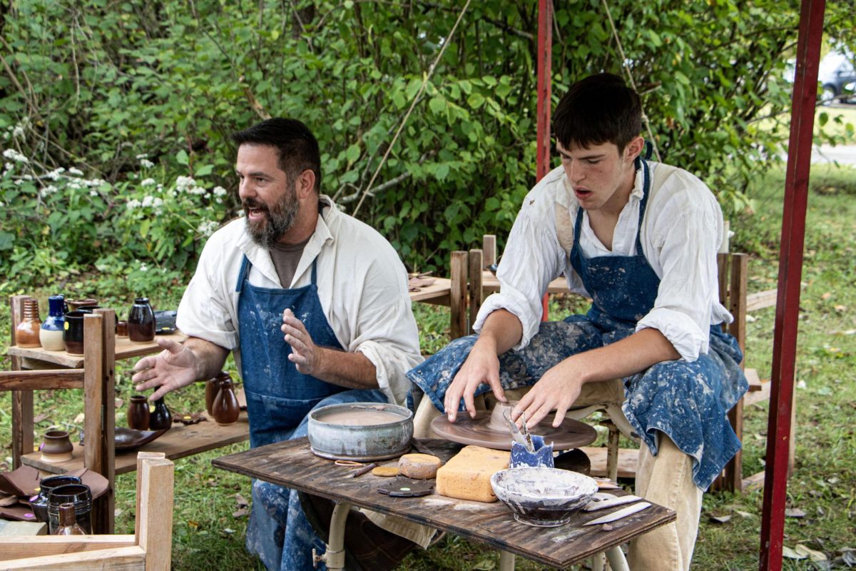 Father and industrial arts teacher at Cumberland High School Jacob Venatta and son, sophomore at Cumberland High School, Isaac Venatta explain their craft to a crowd of people at the Lincoln Log Cabin State Historic Site.