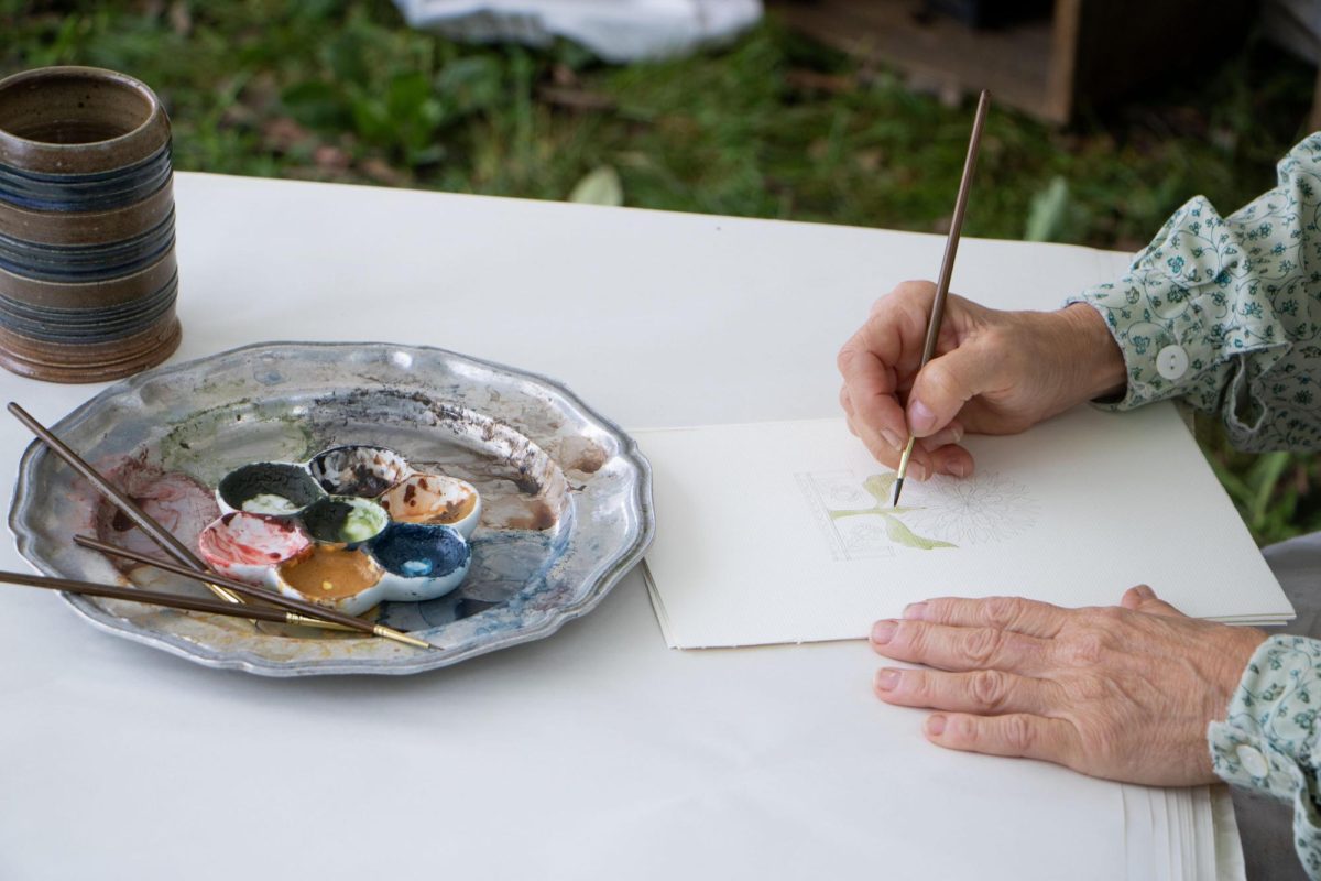 Eighteenth century watercolor painter Valerie Skinner works on her newest painting at Harvest Frolic at the Lincoln Log Cabin State Historic Site