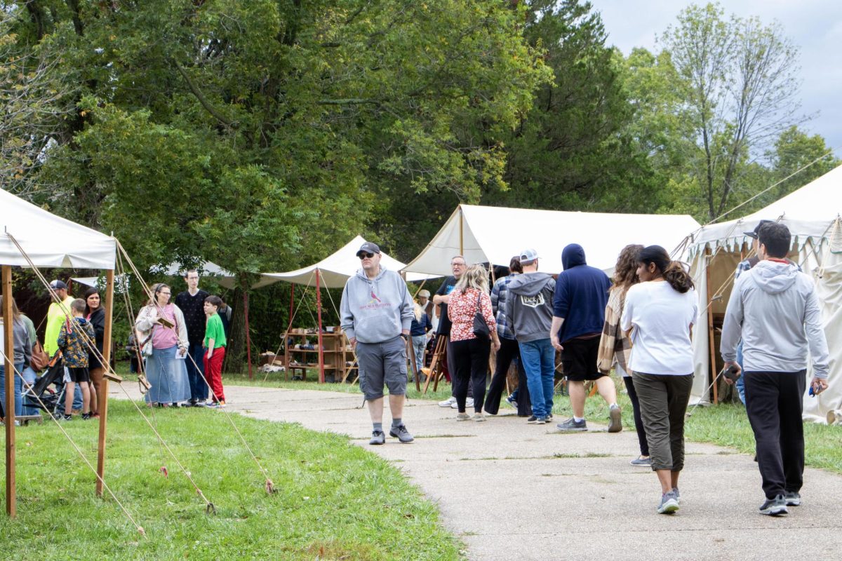 Visitors walk through artisan vendor and performer tents at the at Harvest Frolic at the Lincoln Log Cabin State Historic Site.