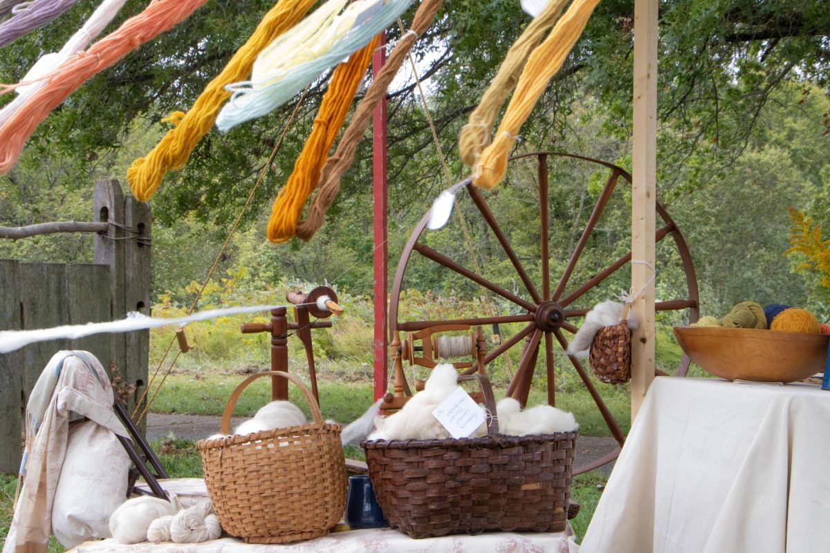 Colorful yarn flows in the wind at a historic stand showcasing a spinning wheel at the Lincoln Log Cabin State Historic Site.