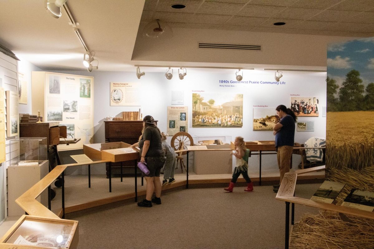 Savannah Polick (left) and Jackson Bosewell read an informational board while Kelton Nichols (right) and Lily Bosewell explore the historical exhibition at the Lincoln Log Cabin State Historic Site.