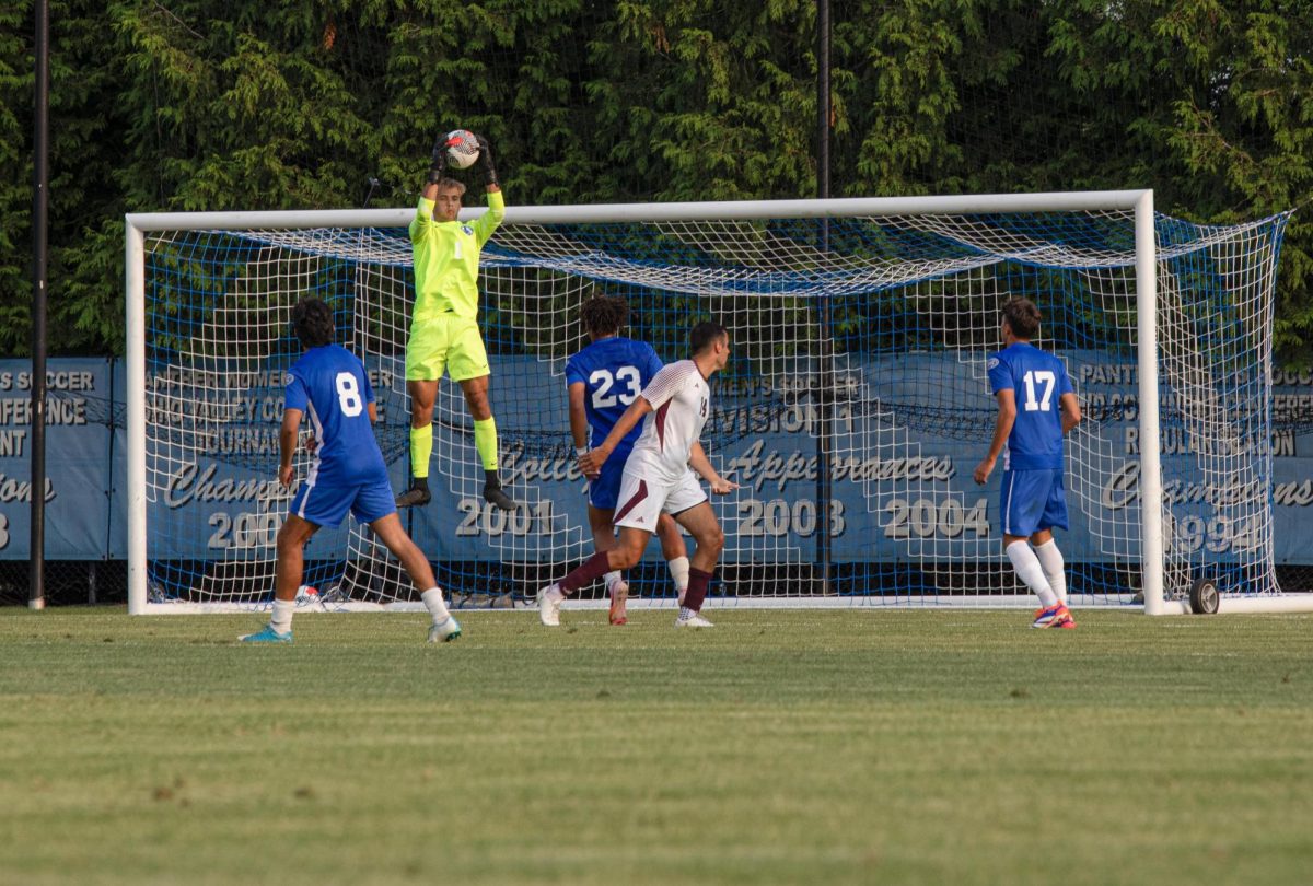 Senior, goalkeeper Chad Smith, leaps into the air to catch the ball before it goes into the net, Thursday night