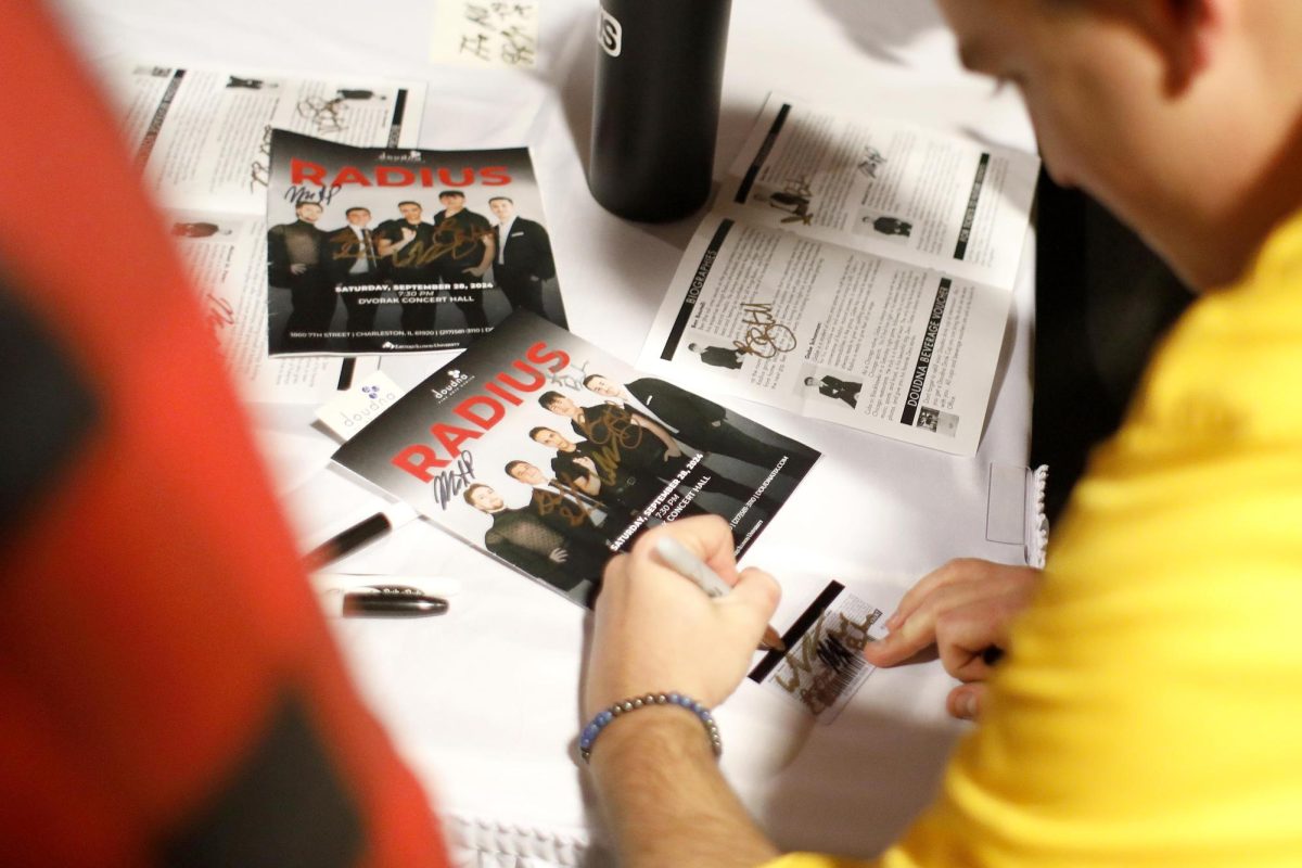 Radius' Gabe Schonman signs an audience member's program and a Blockbuster card at the Doudna Fine Arts Center Saturday evening.