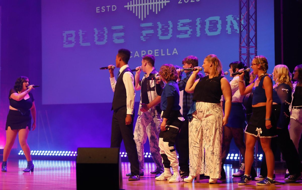 Karrin Estes, a senior music education major, sings the lead part during Blue Fusion's set before the start of Radius at the Doudna Fine Arts Center Saturday evening.