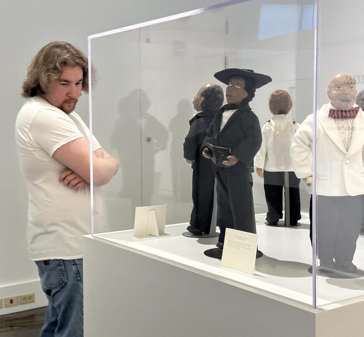 Charleston resident Jackson Boatman views the Dolls of Ida Roberta Bell, made to resemble famous black Americans, in the front room of the Tarble Arts Center at the opening 