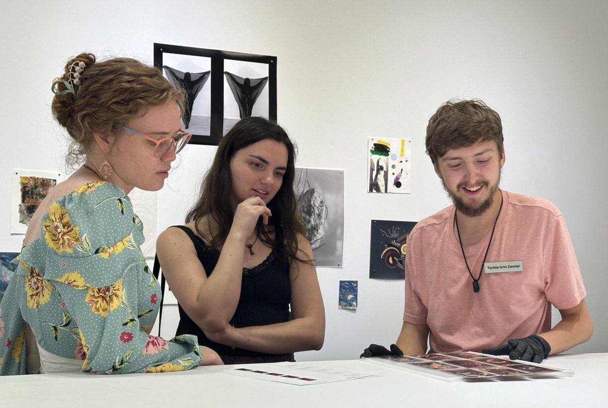 Tarble employee and art graduate student Tristen Hahn showcases art in the Touch Me room to art major graduates Chloe Flanigan and Pamela Zimmerman the Tarble Arts Center at the opening reception on Friday, Sept. 20.