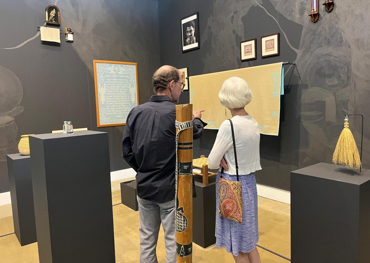 Visitors view "She who brings her own things" by artist glyneshia at the Tarble Arts Center Friday. glyneshia's work is made of items from both her personal collection of work and from the Tarble's collection and draws inspiration from Black living spaces.