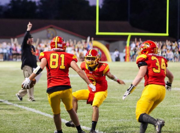 Senior wide receiver Chase Clough jumped to celebrate with senior quarterback after a second quarter touchdown. Head Coach Brian Halsey in the back. at Trojan Hill, Friday Sept, 6,2024, Charleston Ill. 25-18 Trojans won against the Paris Tigers. 