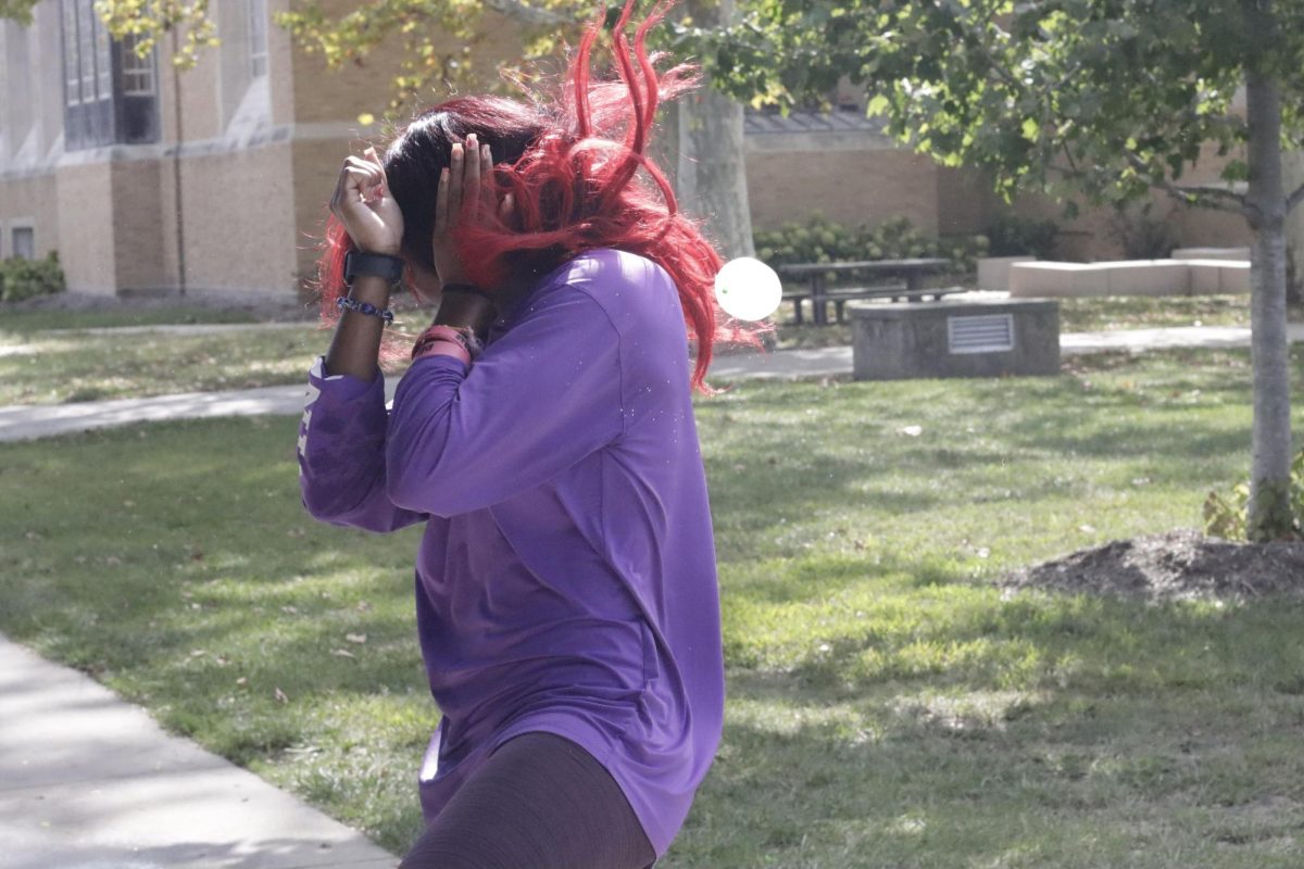 Myricle Mellon, an undecided freshman, protects herself from a water balloon at the Splash a Kat event on Wednesday, Sept., 25, 2024 at the Doudna Fine Arts Center 