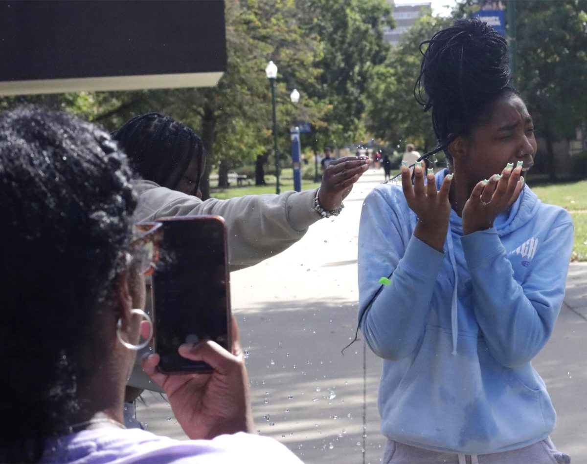 Destinee Patterson, a senior English language arts teacher education major, records Shania Lankston, a senior psychology major, before she gets splashed at the Splash-A-Kat event fundraiser 