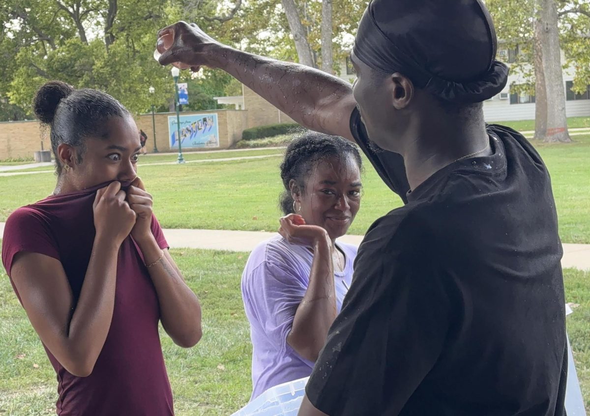 Michael Mboyo, former president of The Kat Walk, prepares to splash Aniyah Landing, a junior psychology major at the Splash-A-Kat event fundraiser