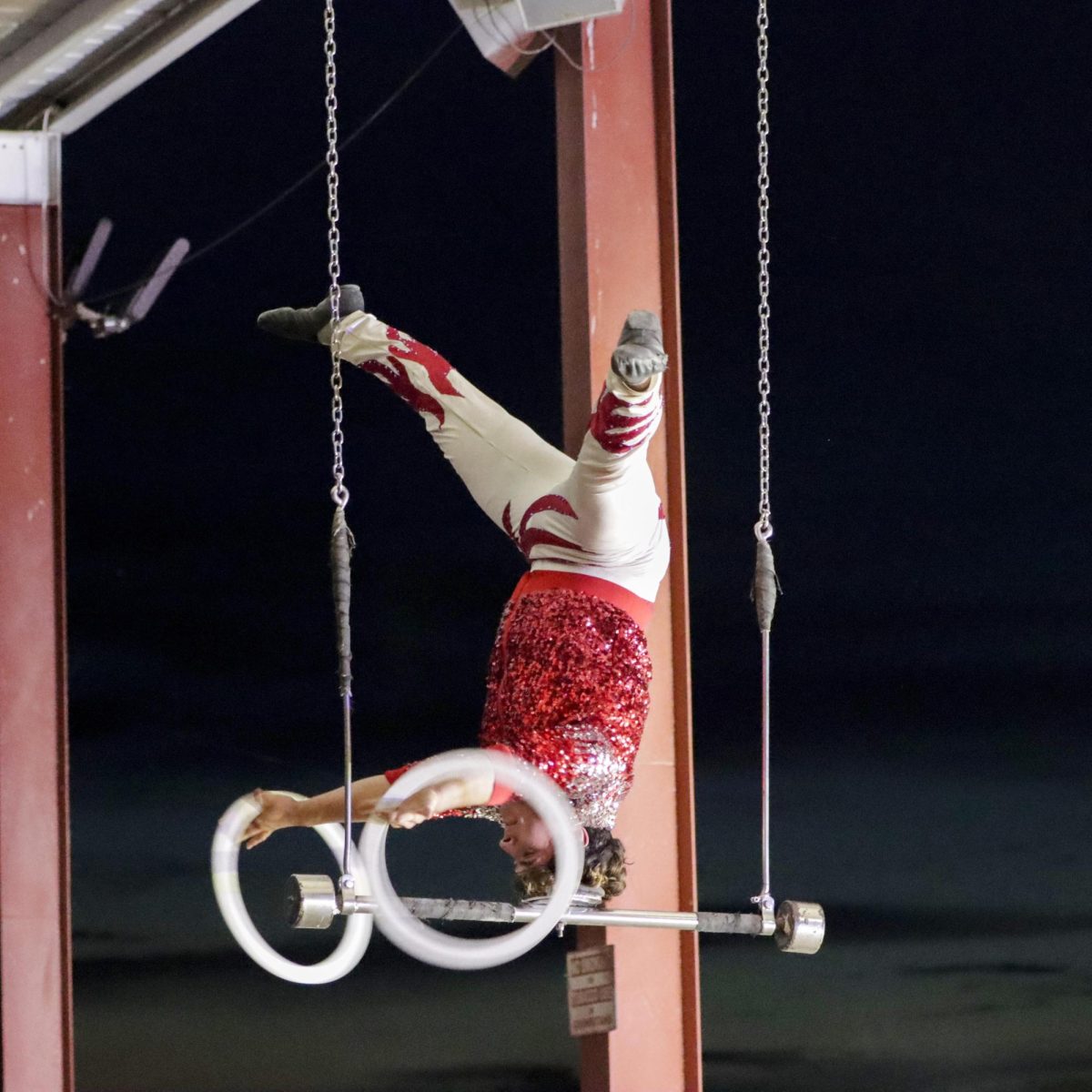 Trapeze artist balances on his head while spinning rings on his hands during the All American Circus' performance held in the Coles County Fairgrounds.