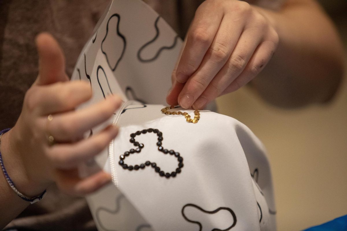 Freshman, biology major Winter Johnson decorates their cowboy hat during the homecoming week event Western Craft Night in the University Ballroom in the Marin Luther King Jr Union 