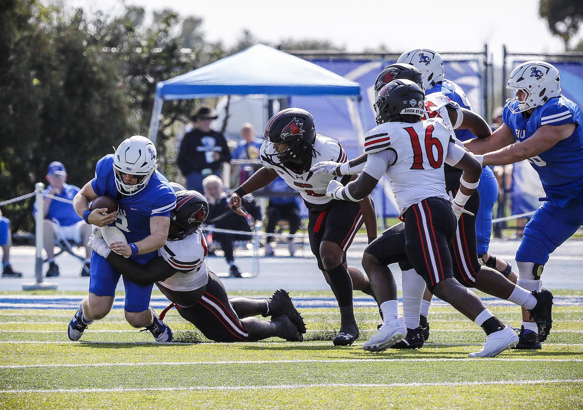 Quarterback Pierce Holley (3), left, is sacked by Southeast Missouri State University Redhawks' defensive line during EIU's homecoming at O'Brien Field against Southeast Missouri State University Saturday afternoon. The Panthers lost 34-27 against the Redhawks.