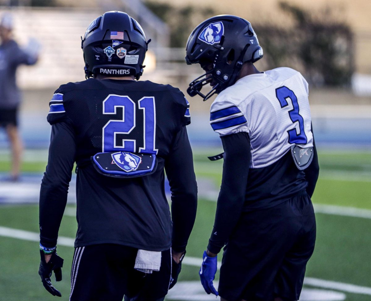 Redshirt Sophomore, runningback, Jay Pearson (21) (left) and defensive back, Junior, NiJhay Burt (3) (right) talk on the sideline during practice, on O'Brien Field on Wed, Oct 30, 