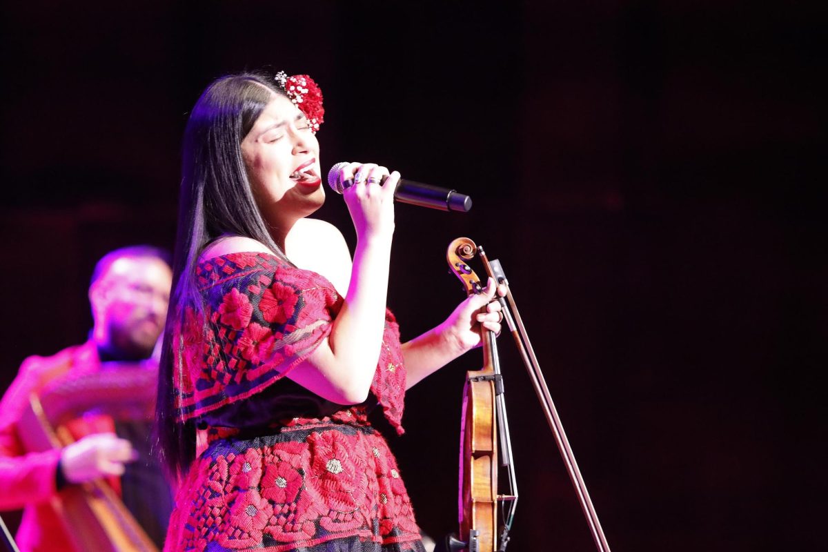 Violinist and vocalist Maria Reyes sings a solo during Grupo Bella's performance in the Dvorak Concert Hall in the Doudna Fine Arts Center Saturday evening. 