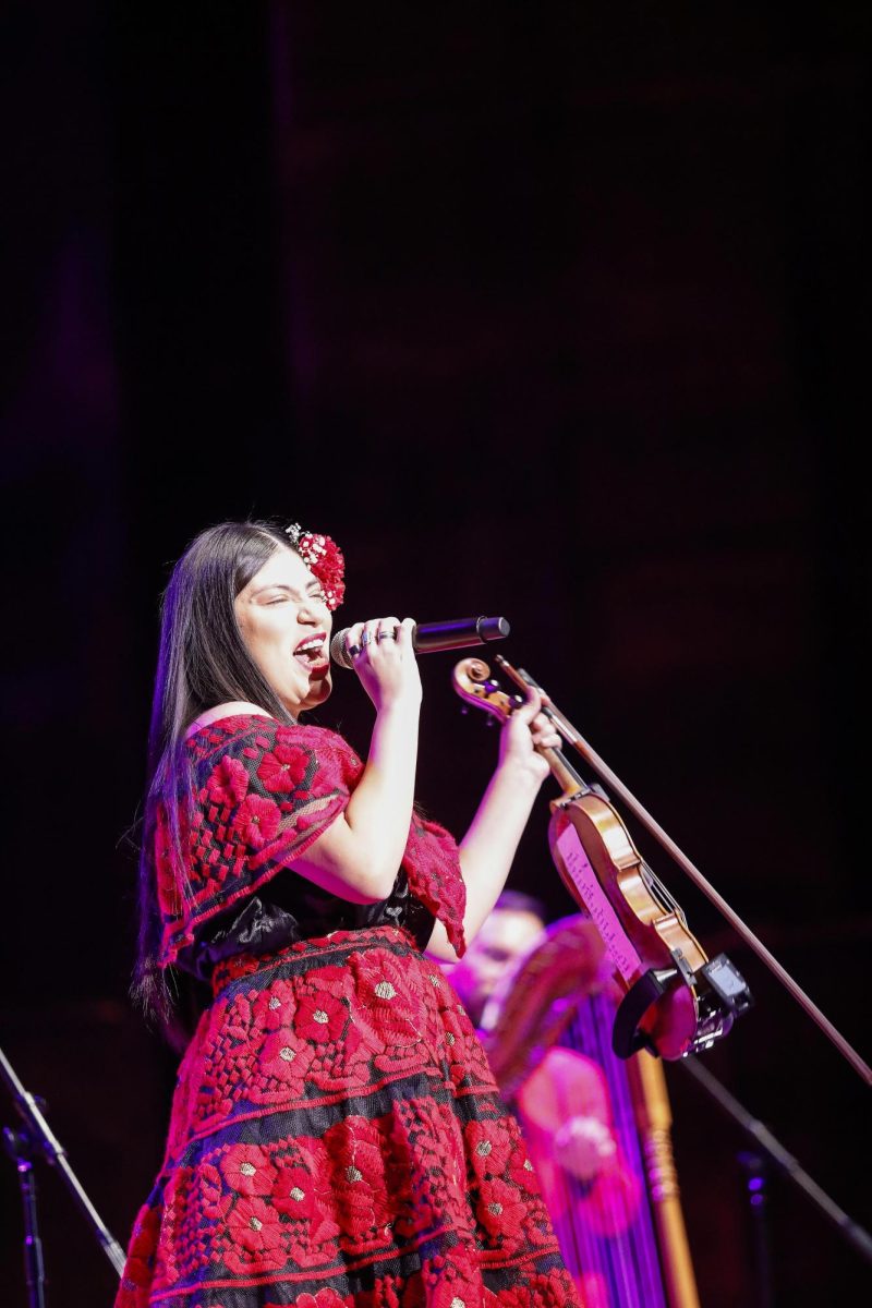 Violinist and vocalist Maria Reyes sings a solo during Grupo Bella's performance in the Dvorak Concert Hall in the Doudna Fine Arts Center Saturday evening. 