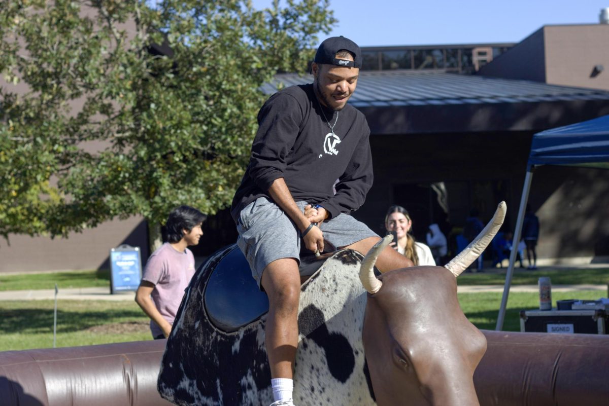 Micah Cherry, a senior in criminal Justice attempts the bull ride this Thursday evening at the Rodeo Round-Up event in the library quad.