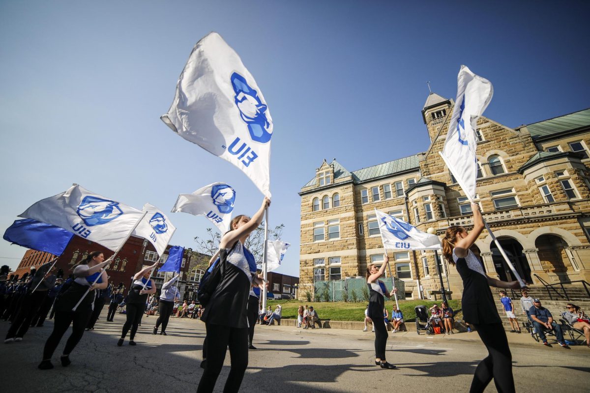 Members of the EIU Panther Color Guard twirl their flags in front of the Coles County Courthouse during the homecoming parade Saturday morning.