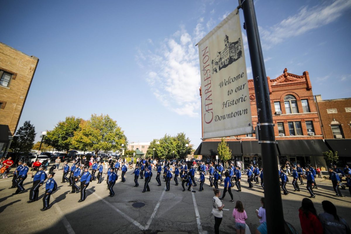 Members of the Panther Marching Band chant along to EIU pep songs in front of the Coles County Courthouse during the homecoming parade Saturday morning.