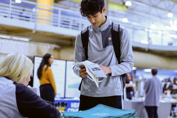 Wesley Koeppl, a freshman in physical education, checks out the Dail-A-Ride stand at the Health and Wellness fair in the Eastern Illinois University Recreation Center. 