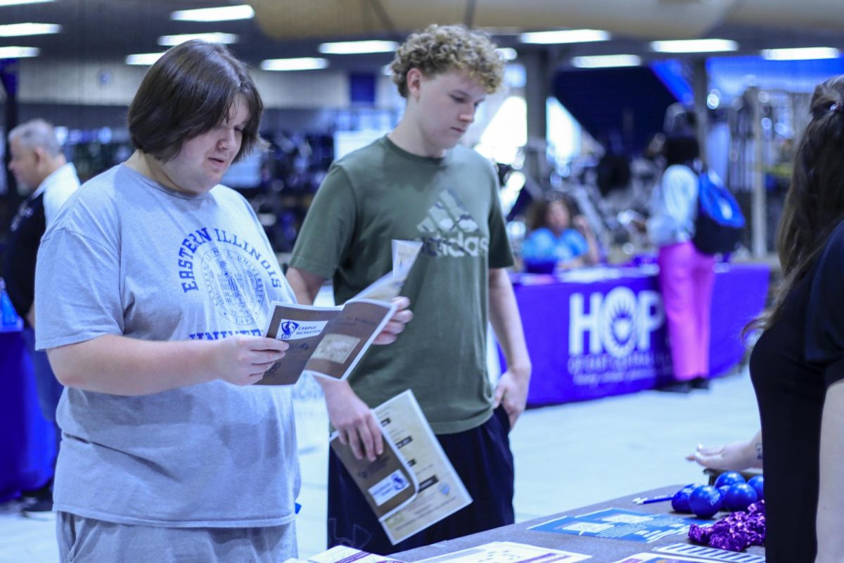 Garrett Wilkerson a freshman in science education and Brennan Ramsey a freshman in sports management learn more about domestic abuse awareness with the IVAT table at the health and Wellness fair