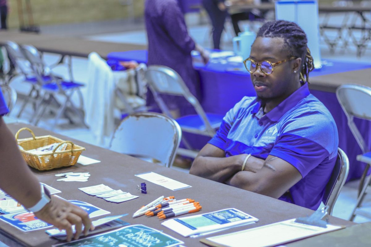  Lesly Nazon, a graduate student in computer technology informs students about the academic support center at the health and Wellness fair 