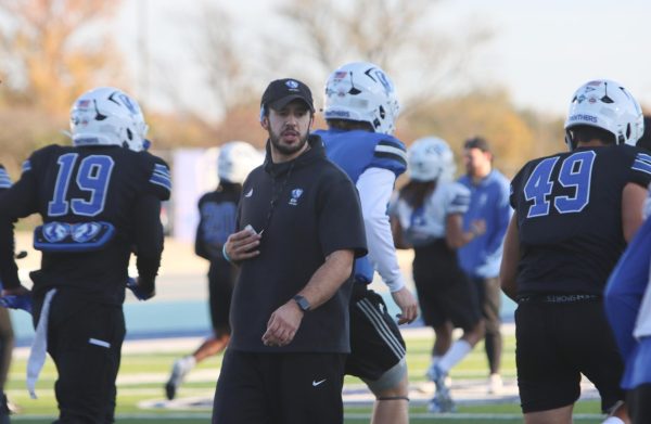 EIU football's Director of Football Performance, Jacob Hillmann, leads a stretch and warmups for the team to get started for practice.